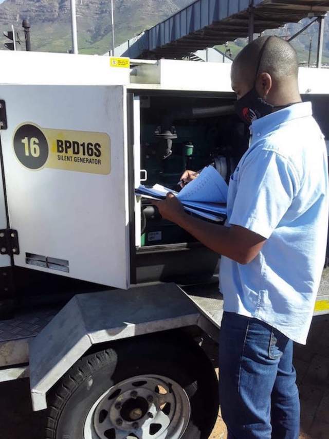 An FM Solutions team  member checks a generator