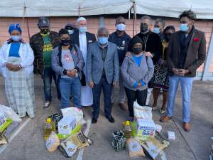 Moti Group Director Ashraf Kaka &amp; Premier Sihle Zikalala &amp; with community members in Crossmore today as they recieved food parcels.