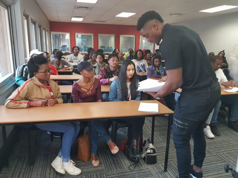 Tino Chinyani lecturing a group of “befuddled university students” 