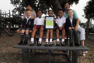 Above: Grade 1 pupils and teachers sit on the new picnic bench made from recycled plastic that they received as their prize in Plastics SA&#039;s Clean-Up and Recycle Competition, whilst proudly showing off their certificate. 